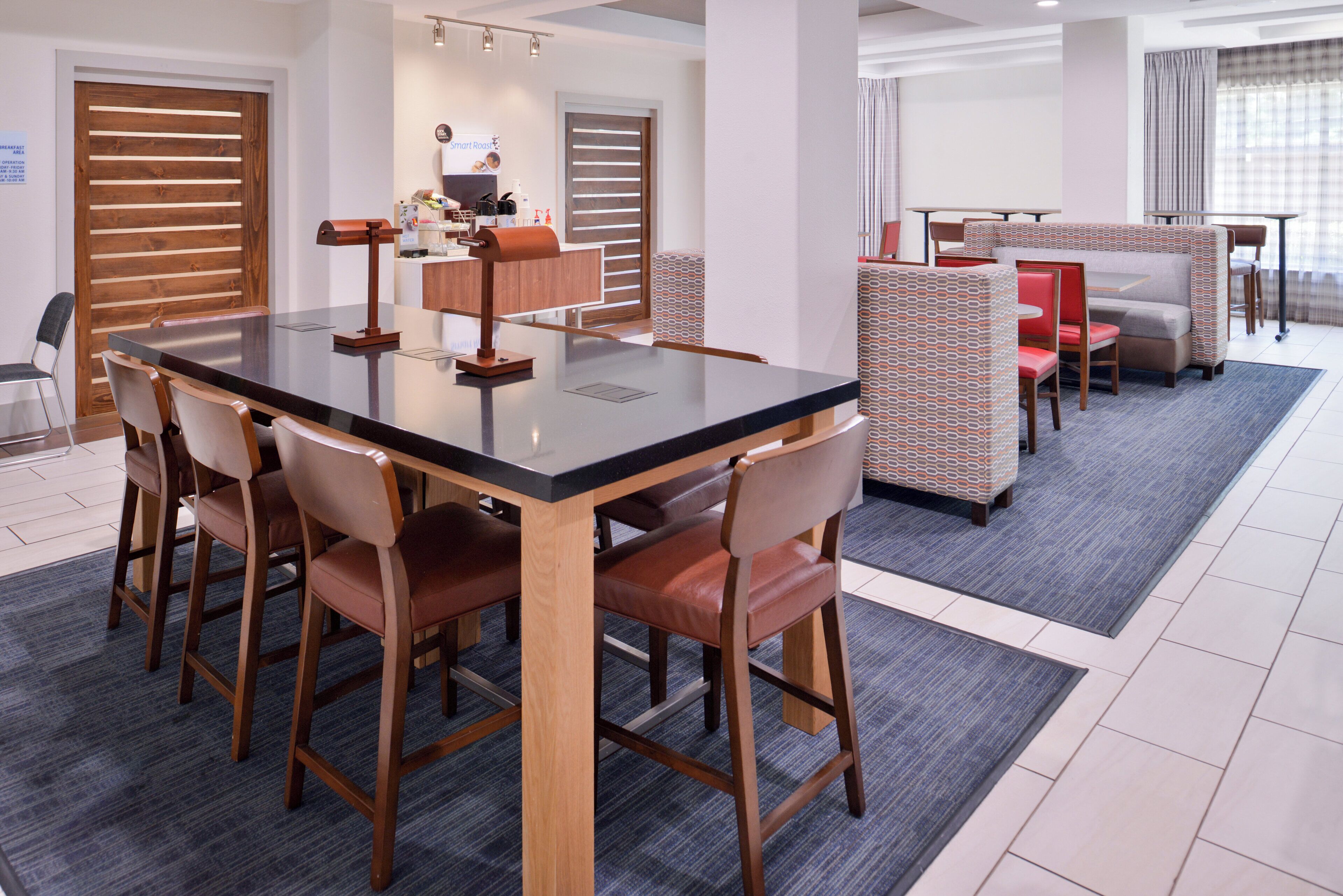 A conference room with a large table, chairs, and a partition.