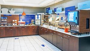 Un espace cuisine moderne comprenant un coin boulangerie, une machine à café et des flèches directionnelles au sol.