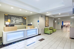 A hotel reception area with a modern design, featuring a reception desk, seating area, and a hallway leading to other rooms. - Holiday Inn Express Hotel & Suites Lafayette South by IHG (Lafayette)