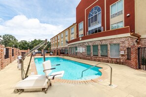 A hotel with a swimming pool, a covered patio, and a brick facade. - Holiday Inn Express Hotel & Suites Lafayette South by IHG (Lafayette)