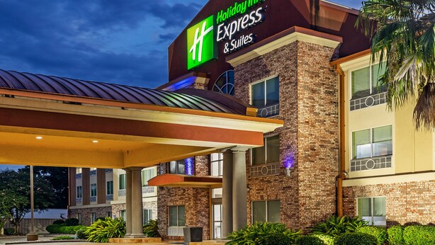 Un bâtiment de la chaîne Holiday Inn Express & Suites, avec une façade en briques et un toit plat.