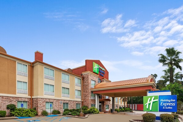 A Holiday Inn Express & Suites building with a brick facade, large windows, and a covered entrance. - Holiday Inn Express Hotel & Suites Lafayette South by IHG (Lafayette)