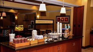 A breakfast bar with various food items and a sign that reads "HAPPY BREAKFAST STARTS HERE". - Hampton Inn Indiana (Indiana)
