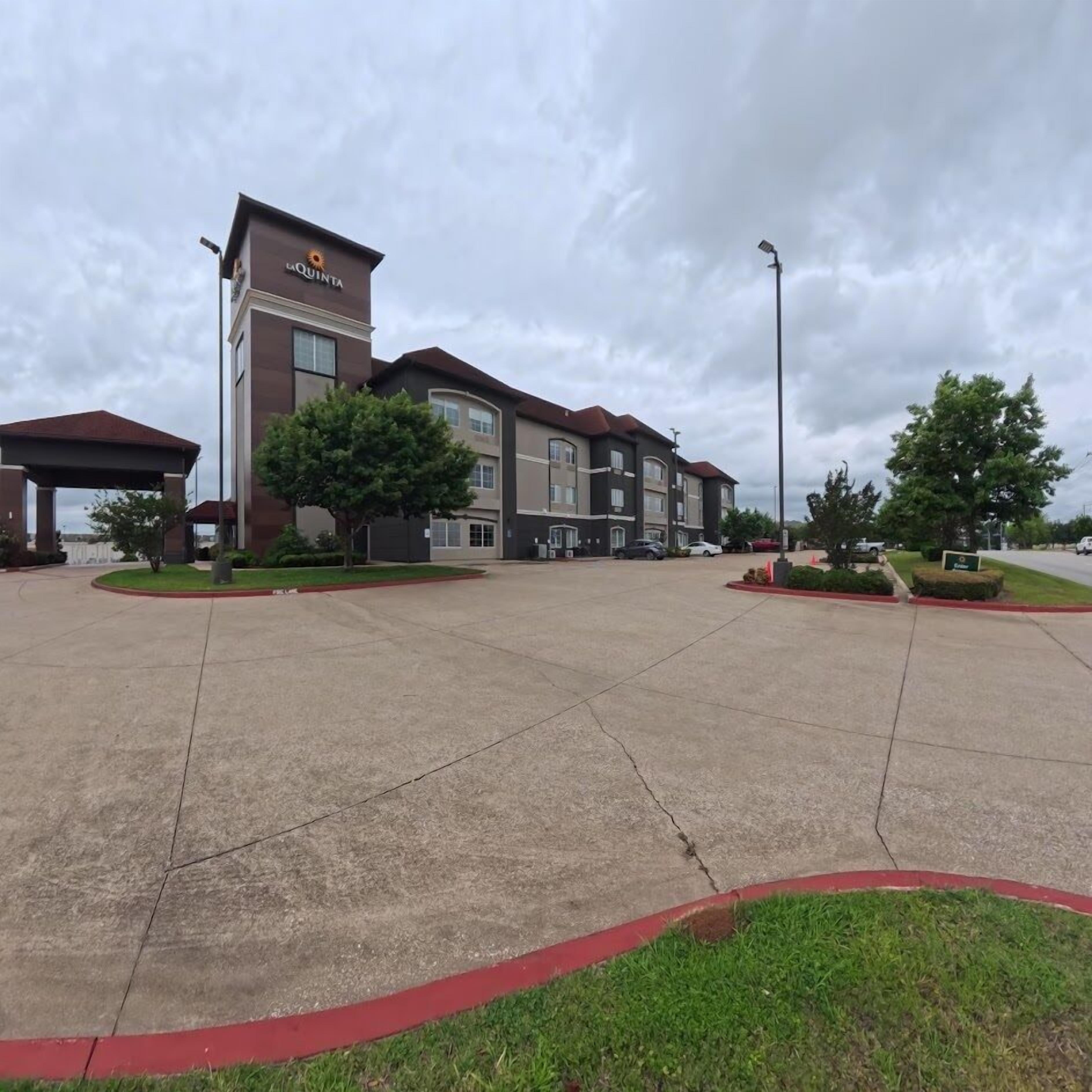 A hotel with a central courtyard, a covered area, and a parking lot.