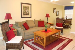 Una sala de estar con un sofá, dos sillones, una mesa de centro y dos lámparas.