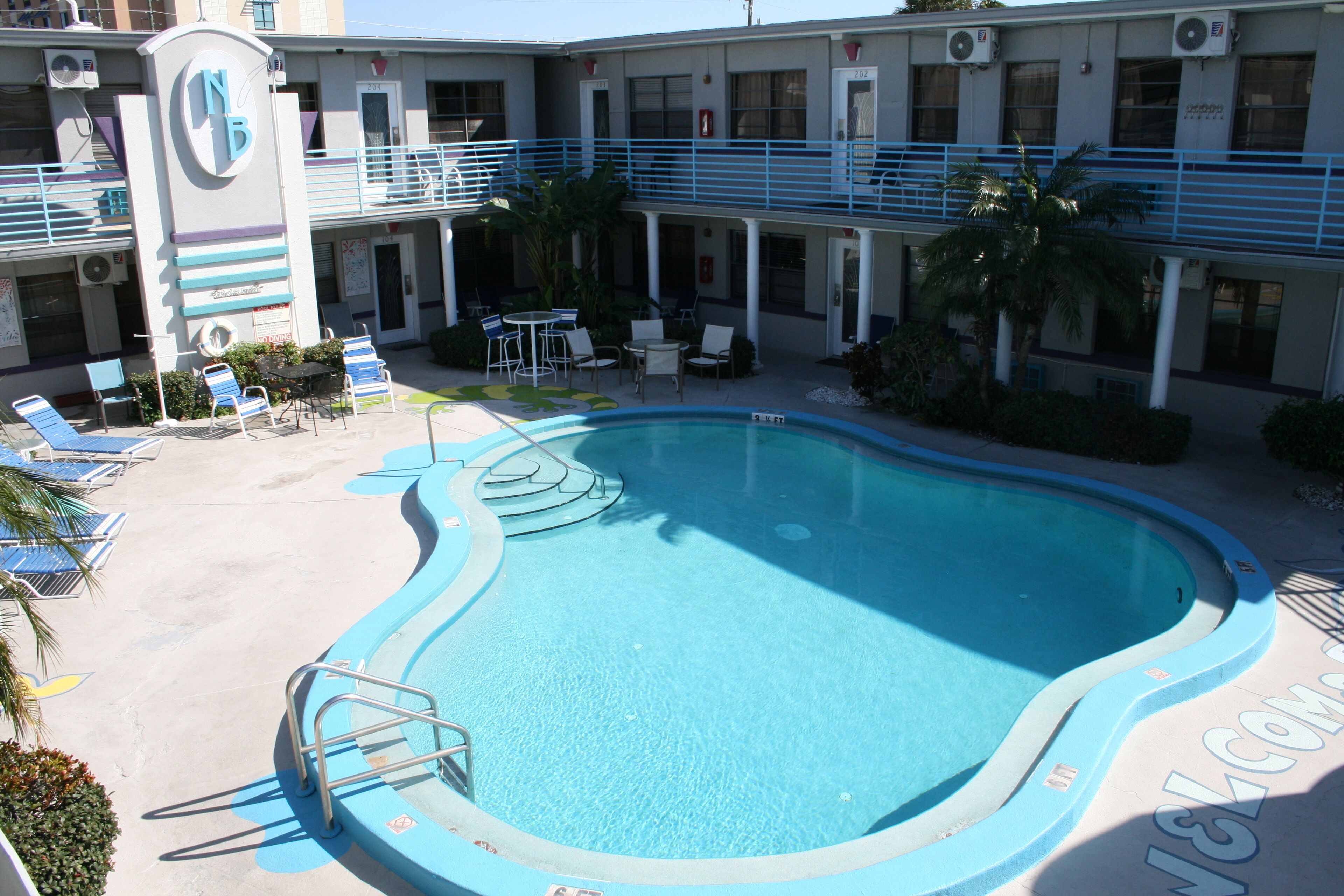 A pool area with lounge chairs and a small table.