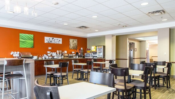 Un restaurant moderne doté d’un bar, de nombreuses tables et chaises, et d’une cuisine située à l’arrière.