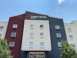 Un edificio de varios pisos con un letrero que dice 'CANDLEWOOD SUITES'.