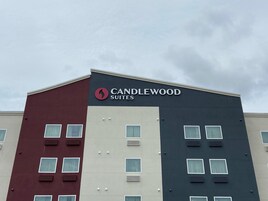 Un edificio de varios pisos con un letrero que dice 'CANDLEWOOD SUITES'.