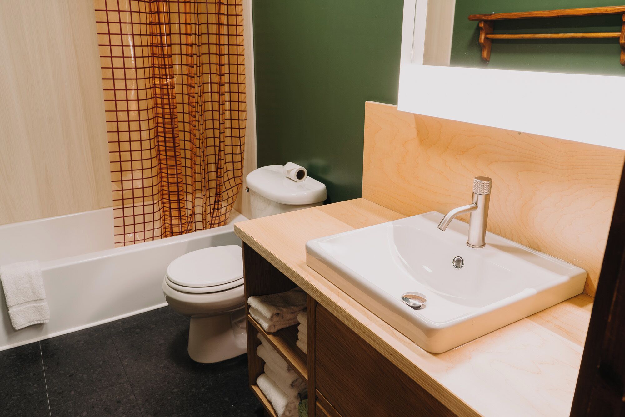 Un bagno con il water, un lavandino e una tenda da doccia.