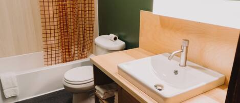 Un bagno con il water, un lavandino e una tenda da doccia.