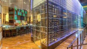 Un espace bar avec un présentoir à vins et des sièges.