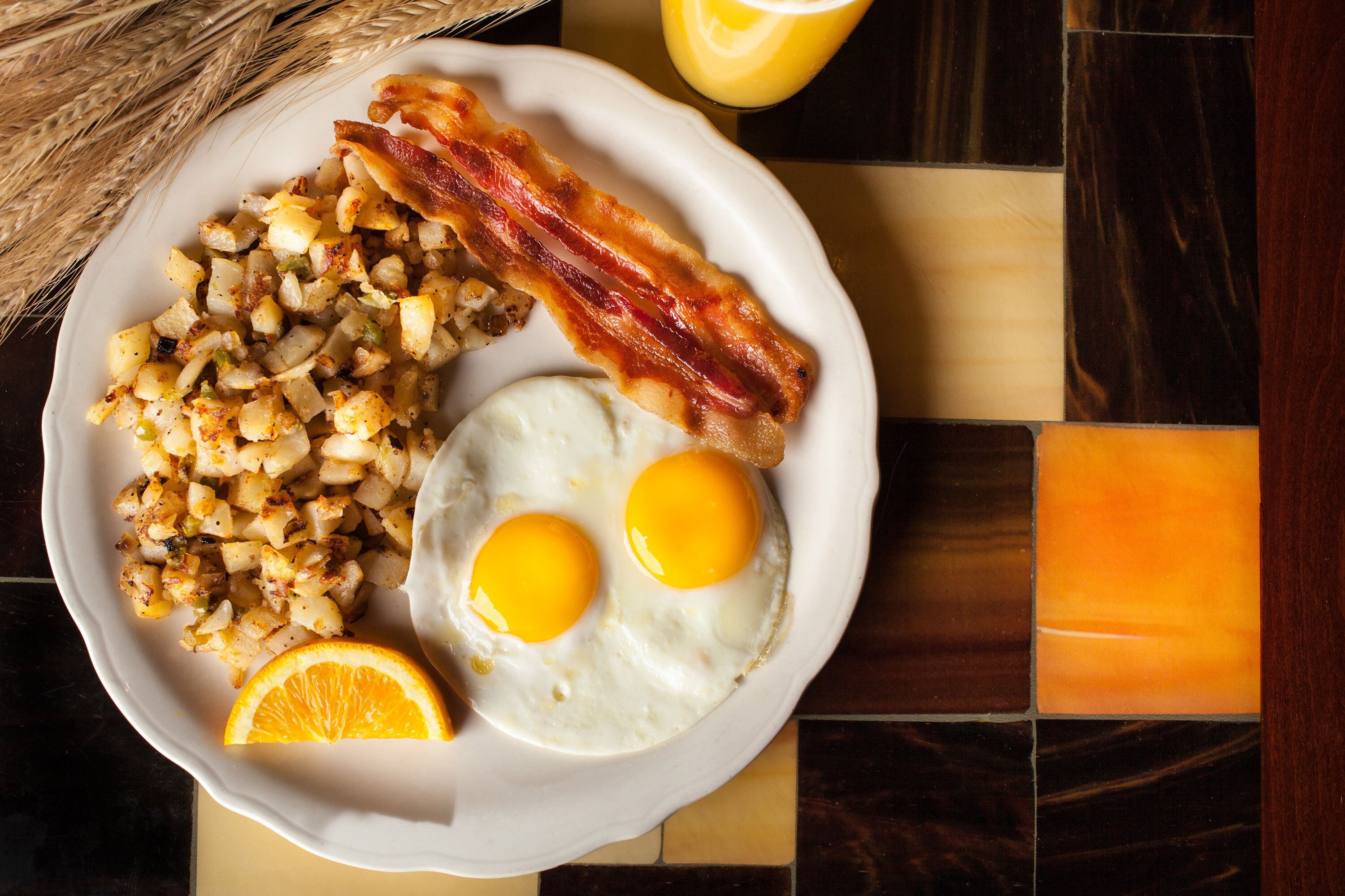 A breakfast plate with eggs, bacon, and potatoes.
