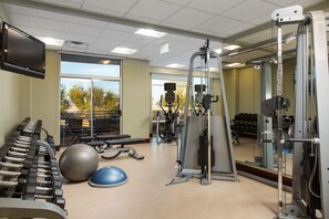Stay fit on the go with our well-equipped gym featuring treadmills, ellipticals, free weights, and a large mirror.