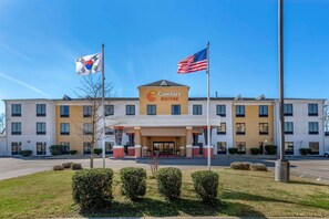 A Comfort Suites hotel with a modern design, featuring a prominent entrance, flagpoles, and well-maintained landscaping. - Comfort Suites Airport South (Montgomery)