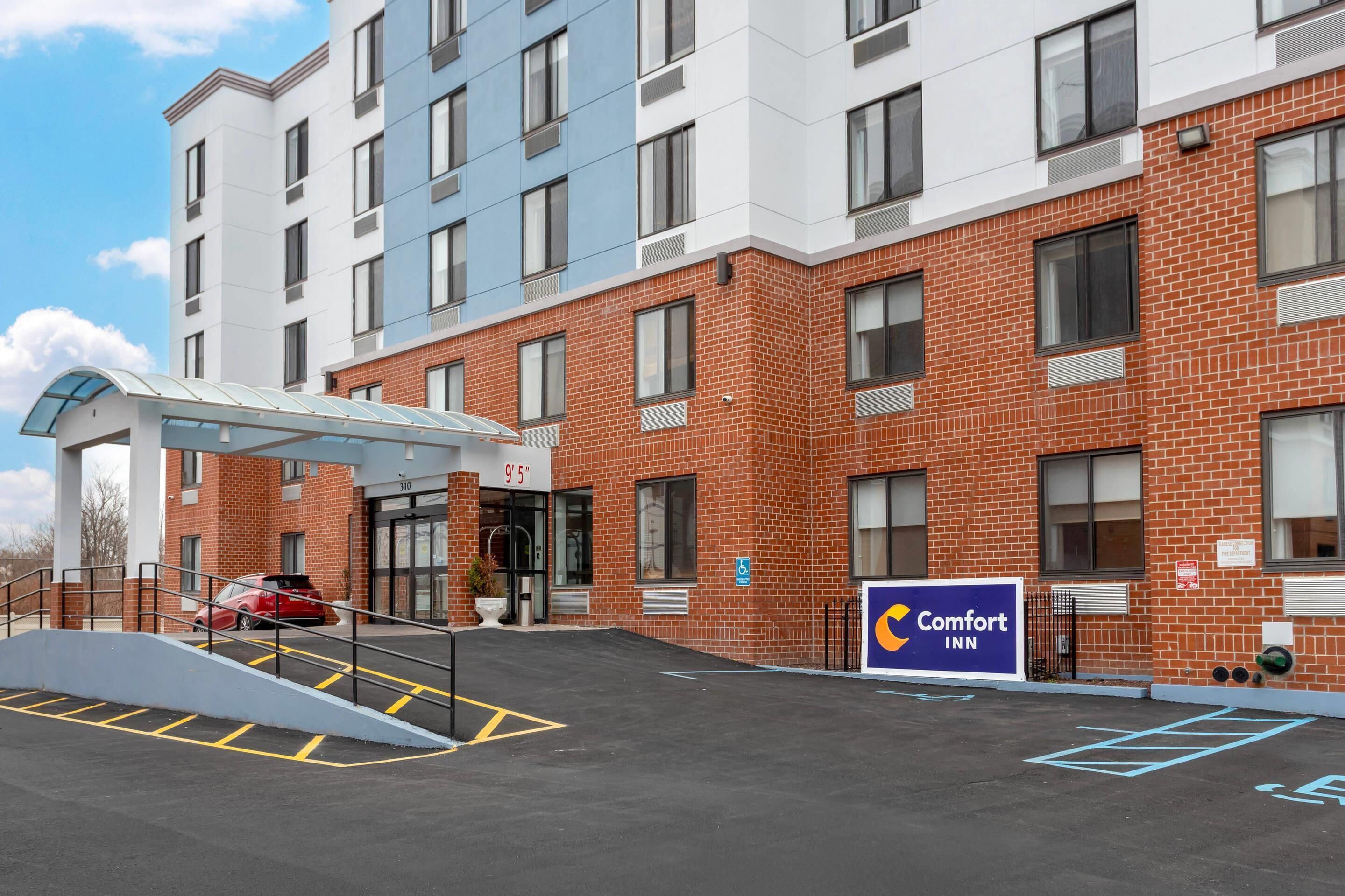 A brick building with a glass entrance and a sign for Comfort Inn.