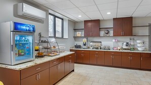 A modern kitchen with a refrigerator, coffee maker, and various appliances. - Comfort Inn Staten Island (Staten Island)