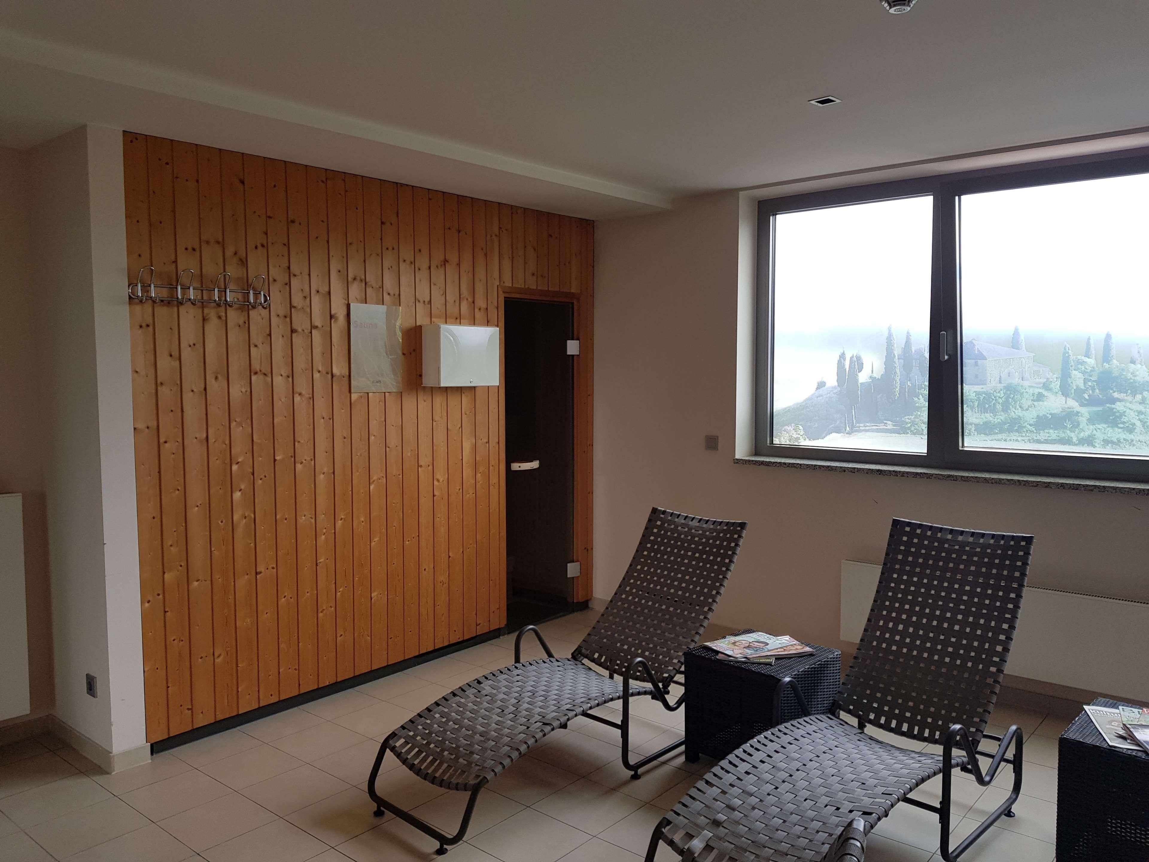 Une pièce comprenant deux fauteuils, un mur en bois, une fenêtre donnant sur un paysage agréable et une porte.