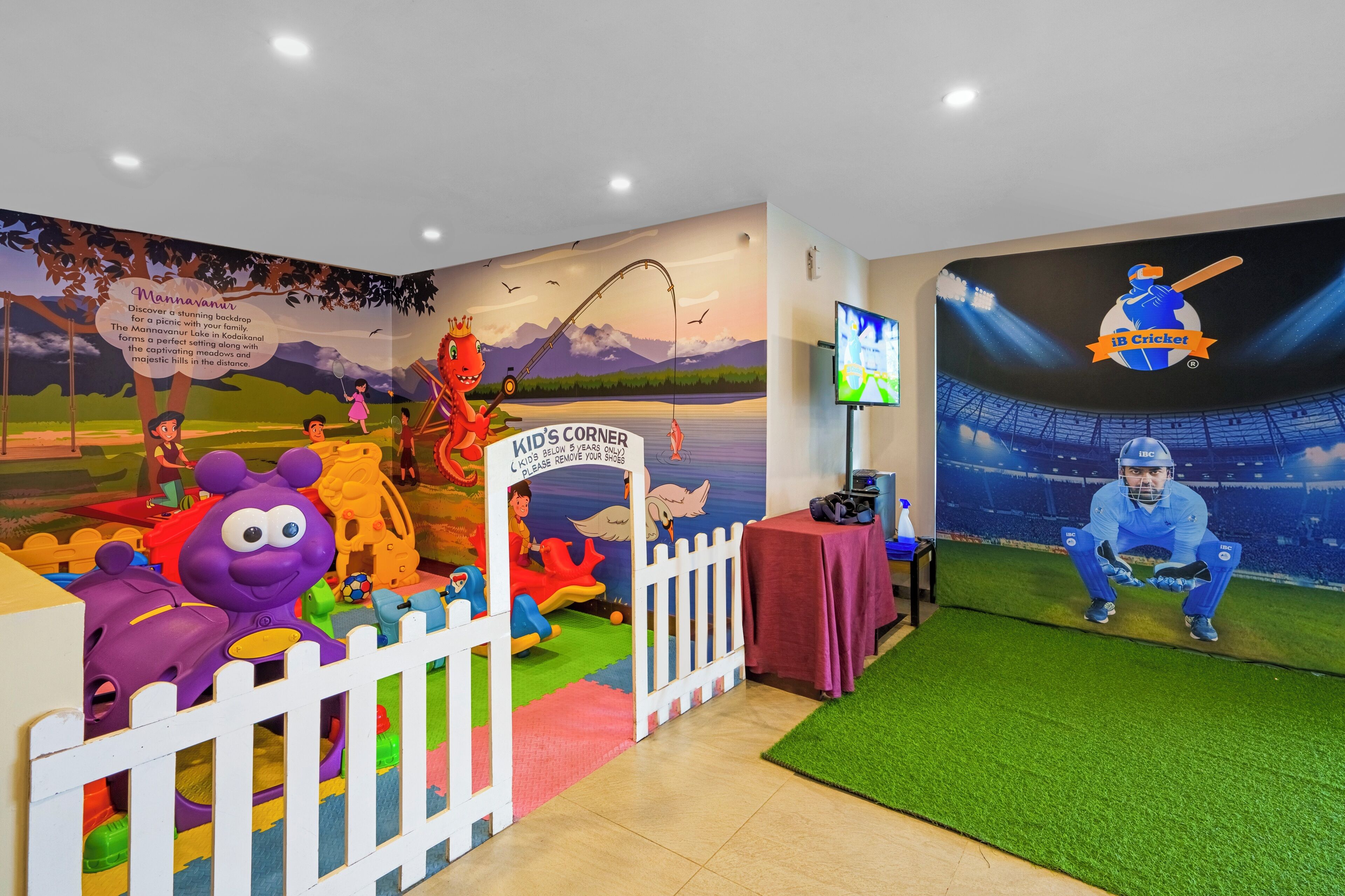 A children's play area with a mural, a white picket fence, and a cricket-themed wall.