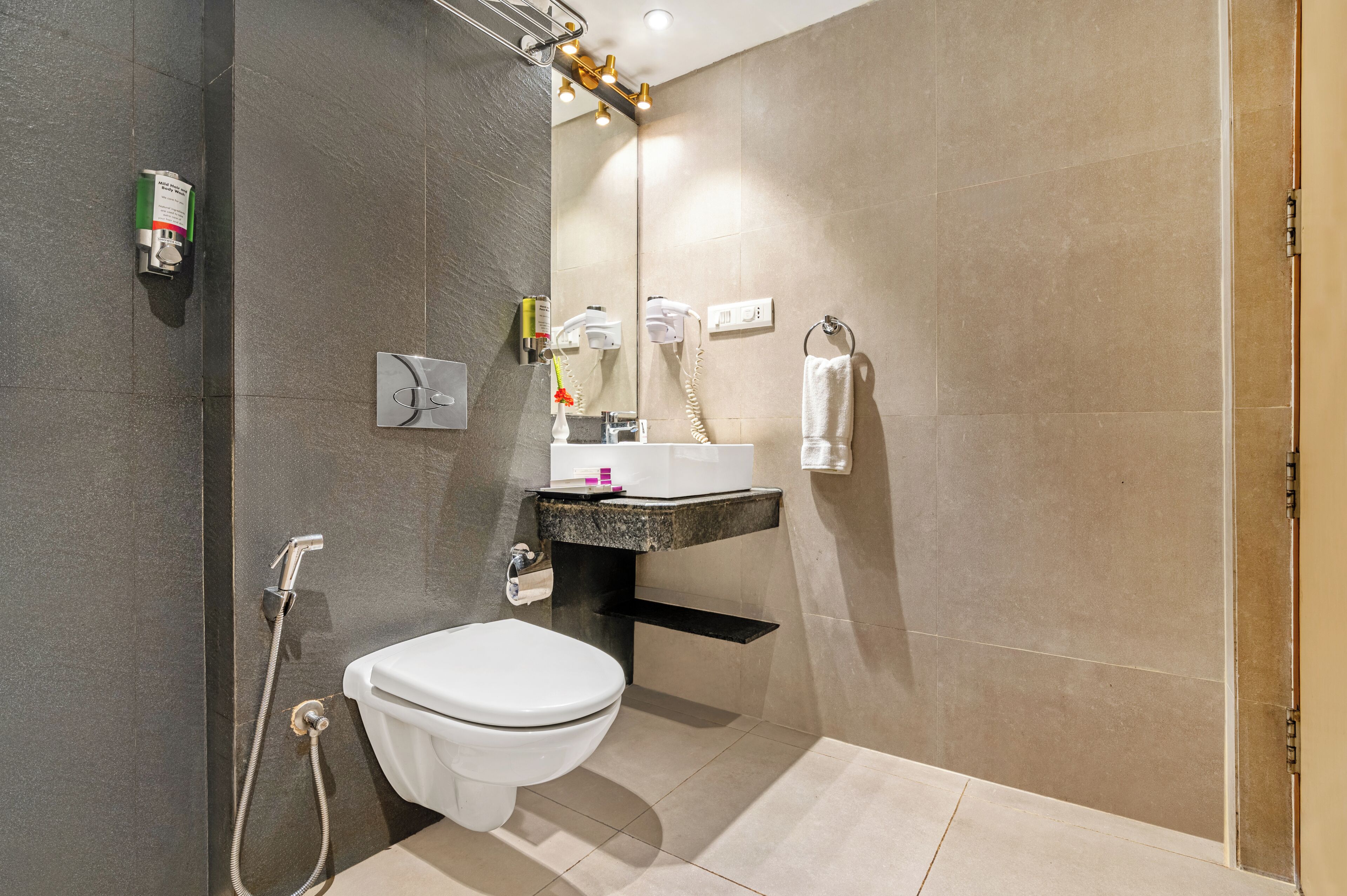 Et moderne badeværelse med toilet, håndvask og brusebad.