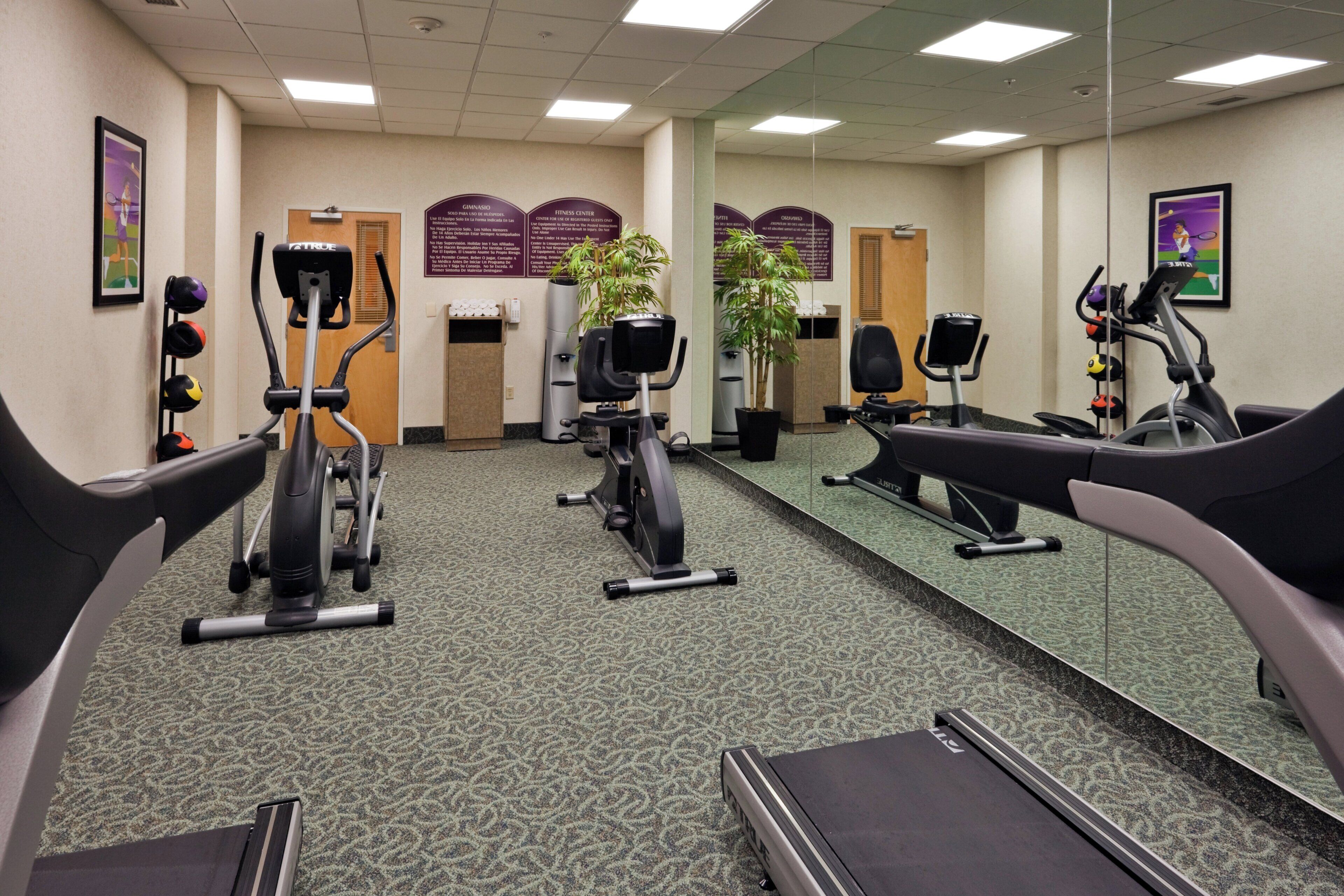 A fitness center with treadmills, stationary bikes, and exercise equipment.