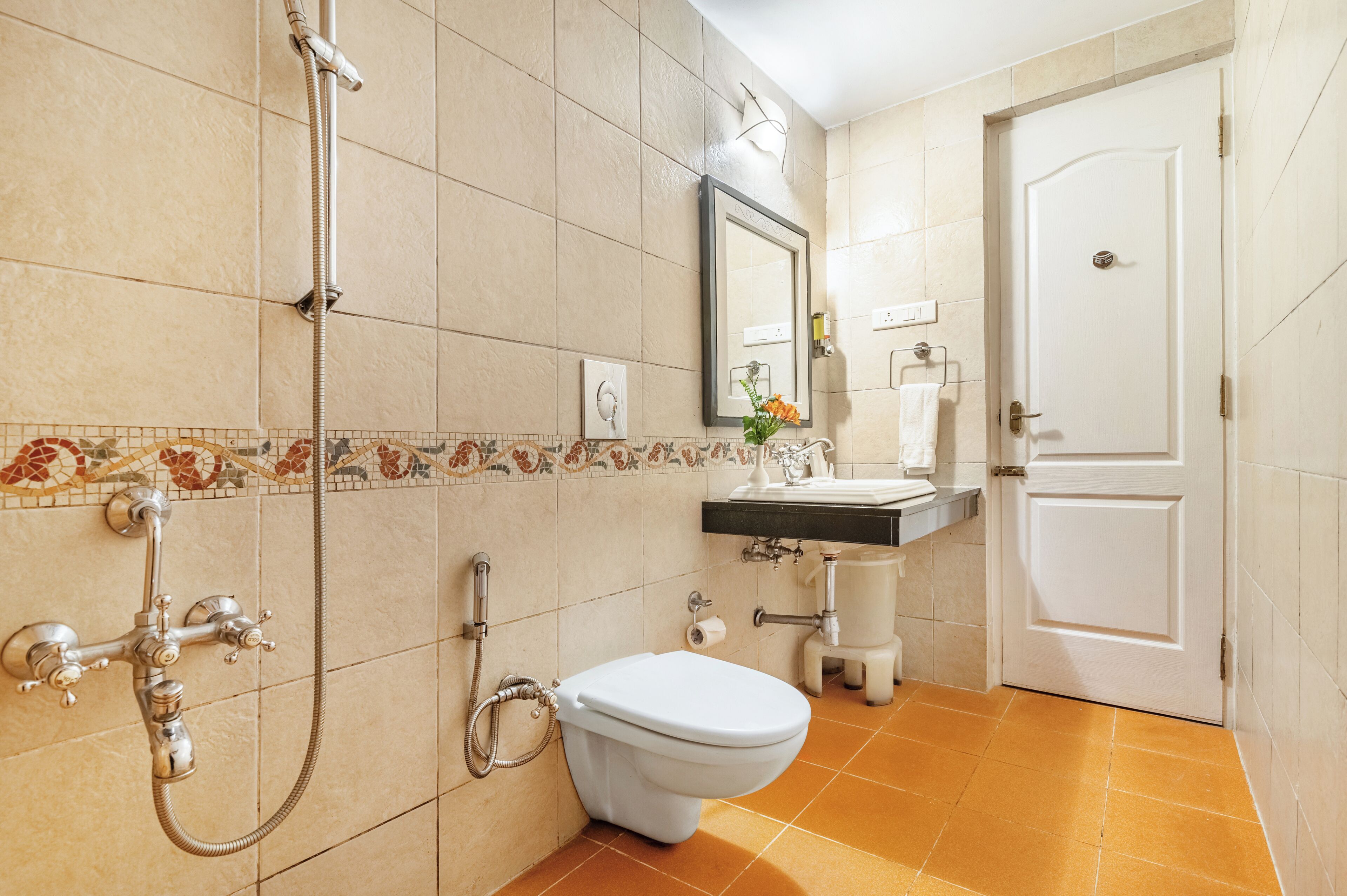 Un bagno con doccia, WC, lavandino e specchio.