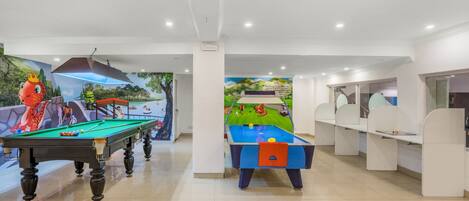 A pool table area with two tables, one with a red octopus decoration and another with a blue tablecloth.