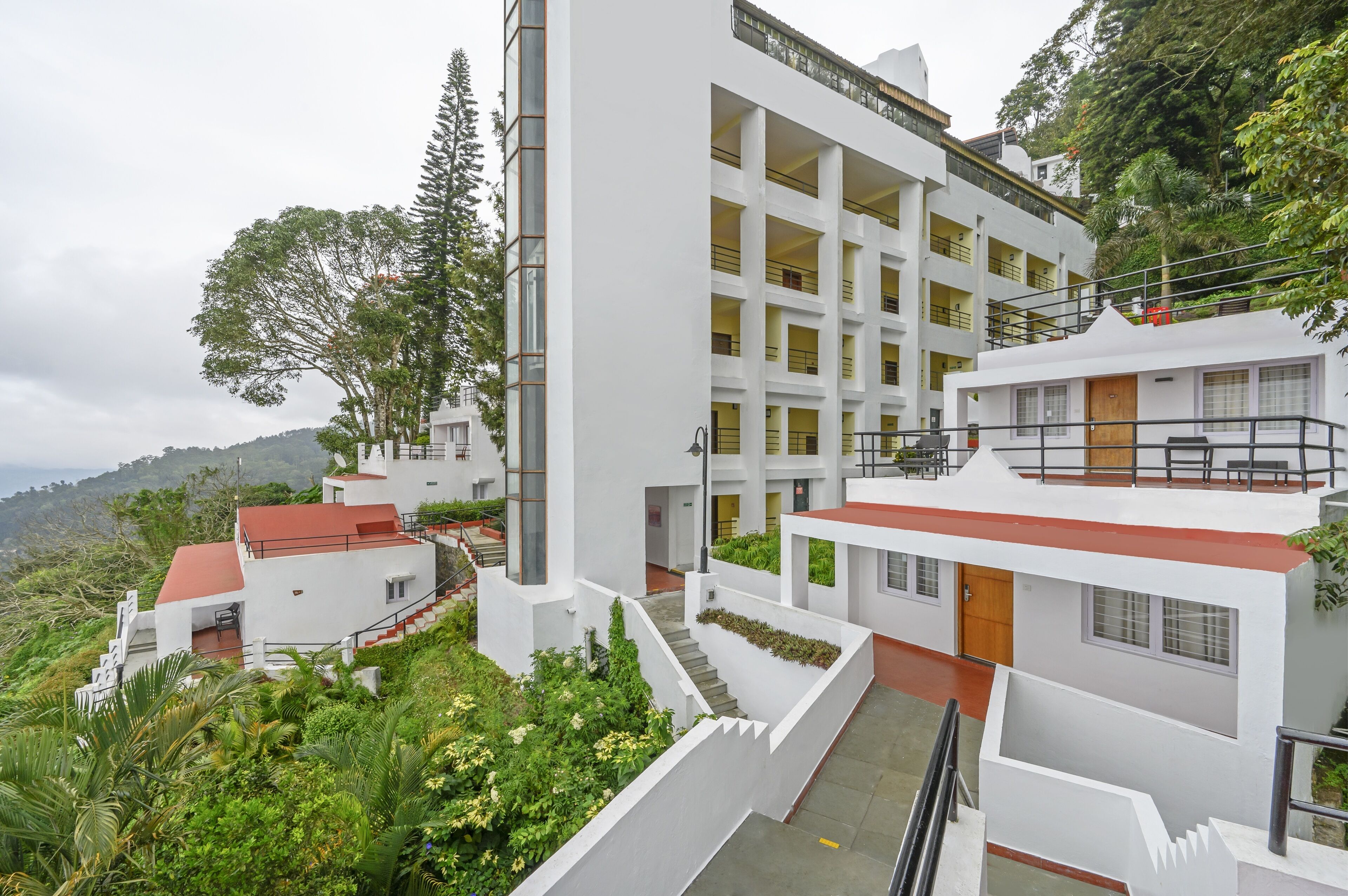 A multi-story hotel with a modern architectural design, featuring a central courtyard and balconies.