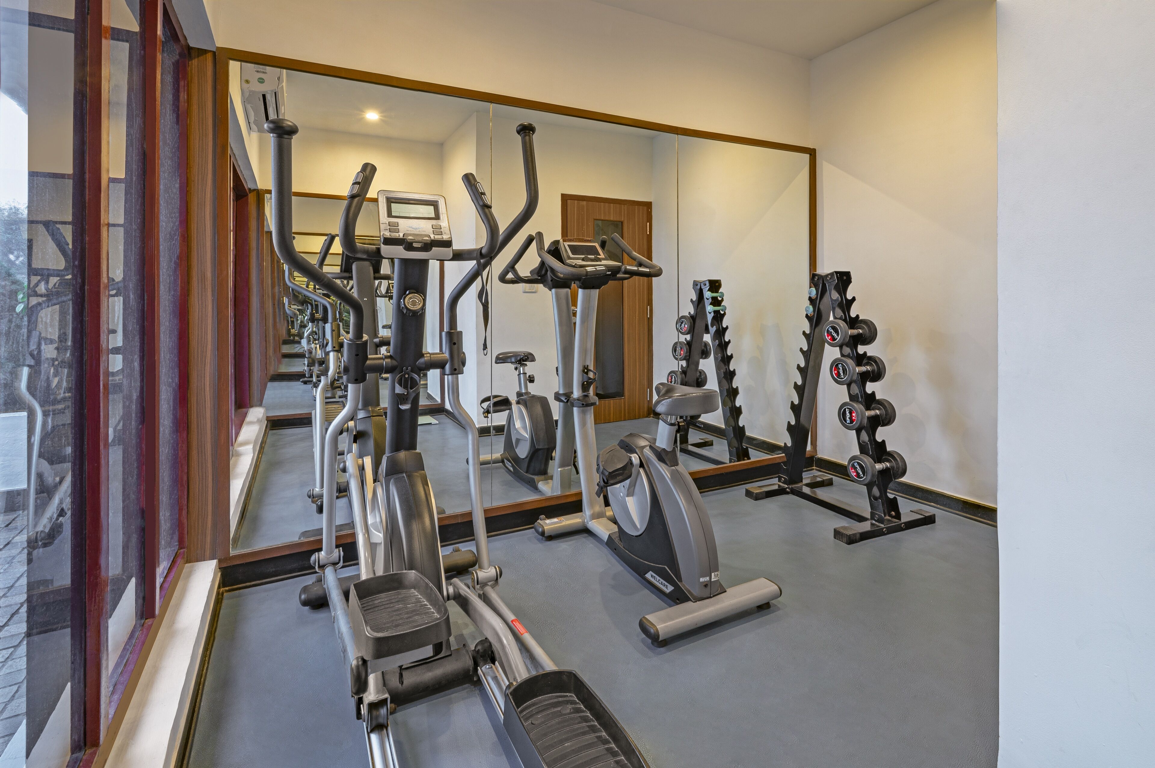 A gym with various exercise equipment, including treadmills, elliptical machines, and weightlifting stations.