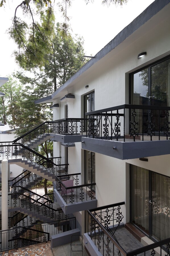 A multi-level building with a central staircase and balconies. - Sterling Munnar (Devikolam)