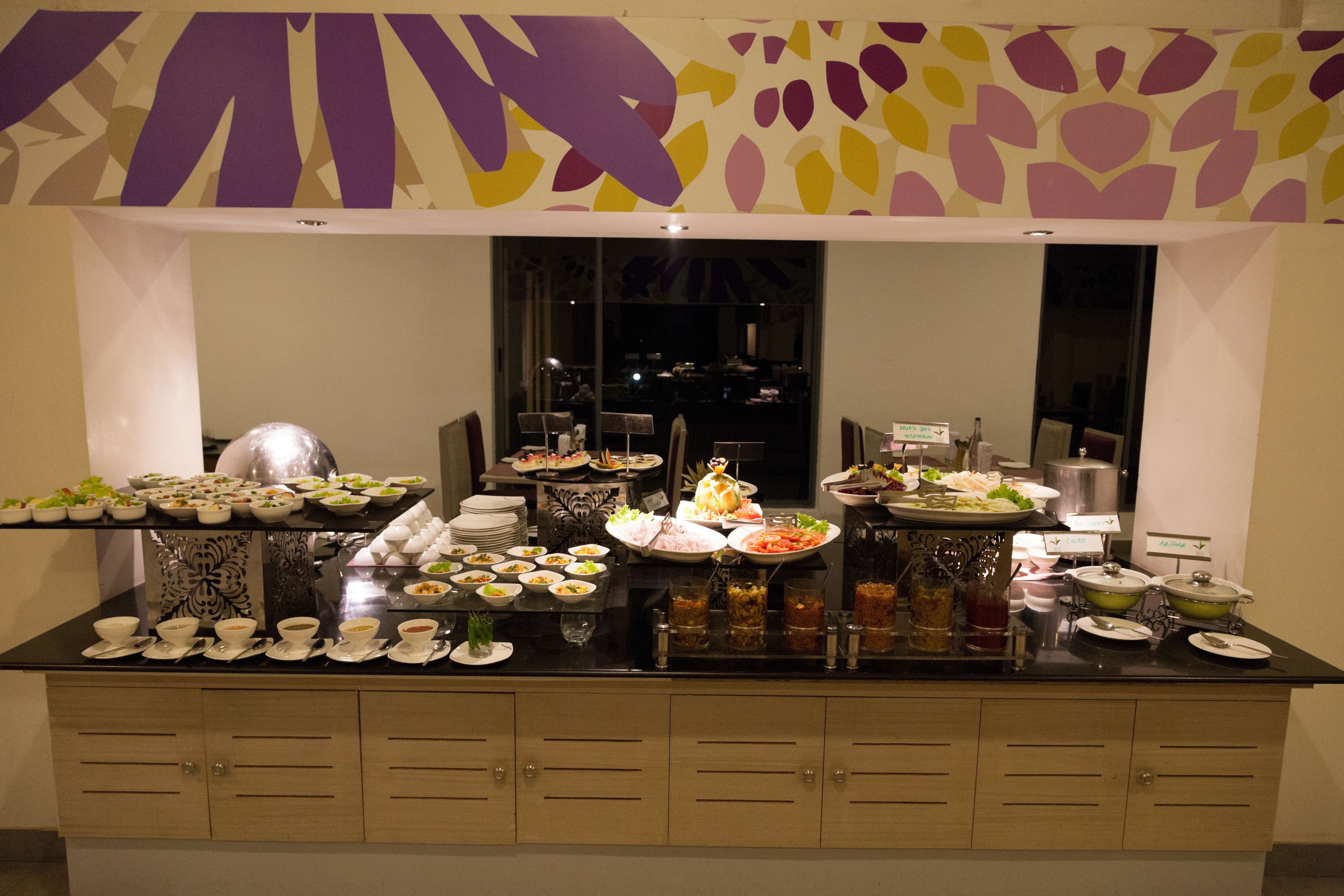 A buffet setup with various food items and beverages.