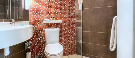 Ein Badezimmer mit Waschbecken, Toilette und Duschbereich.