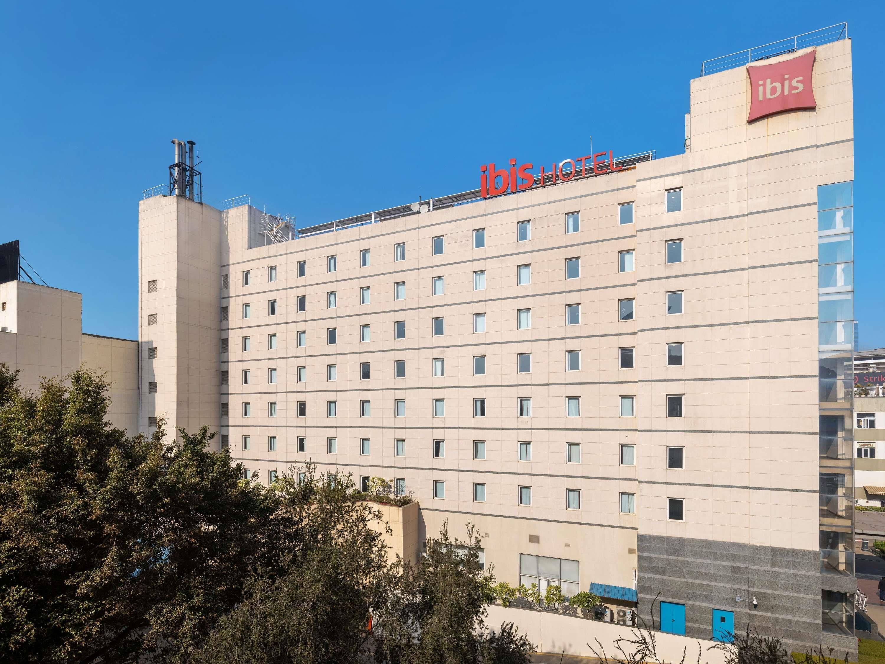 Un bâtiment d’hôtel sur lequel on peut voir, en haut, une grande enseigne indiquant « ibis HOTEL ».