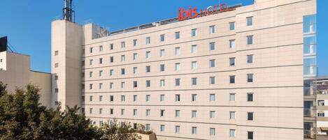 A hotel building with a prominent 'ibis HOTEL' sign on the top.
