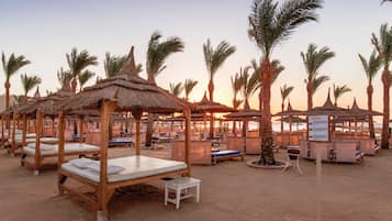 Praia particular, espreguiçadeiras, guarda-sóis, toalhas de praia