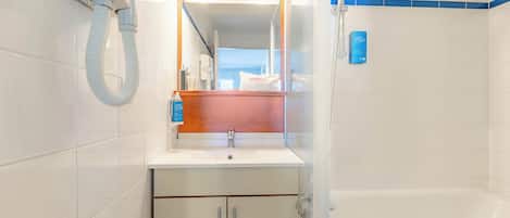 A modern bathroom with a bathtub, a sink, and a mirror.
