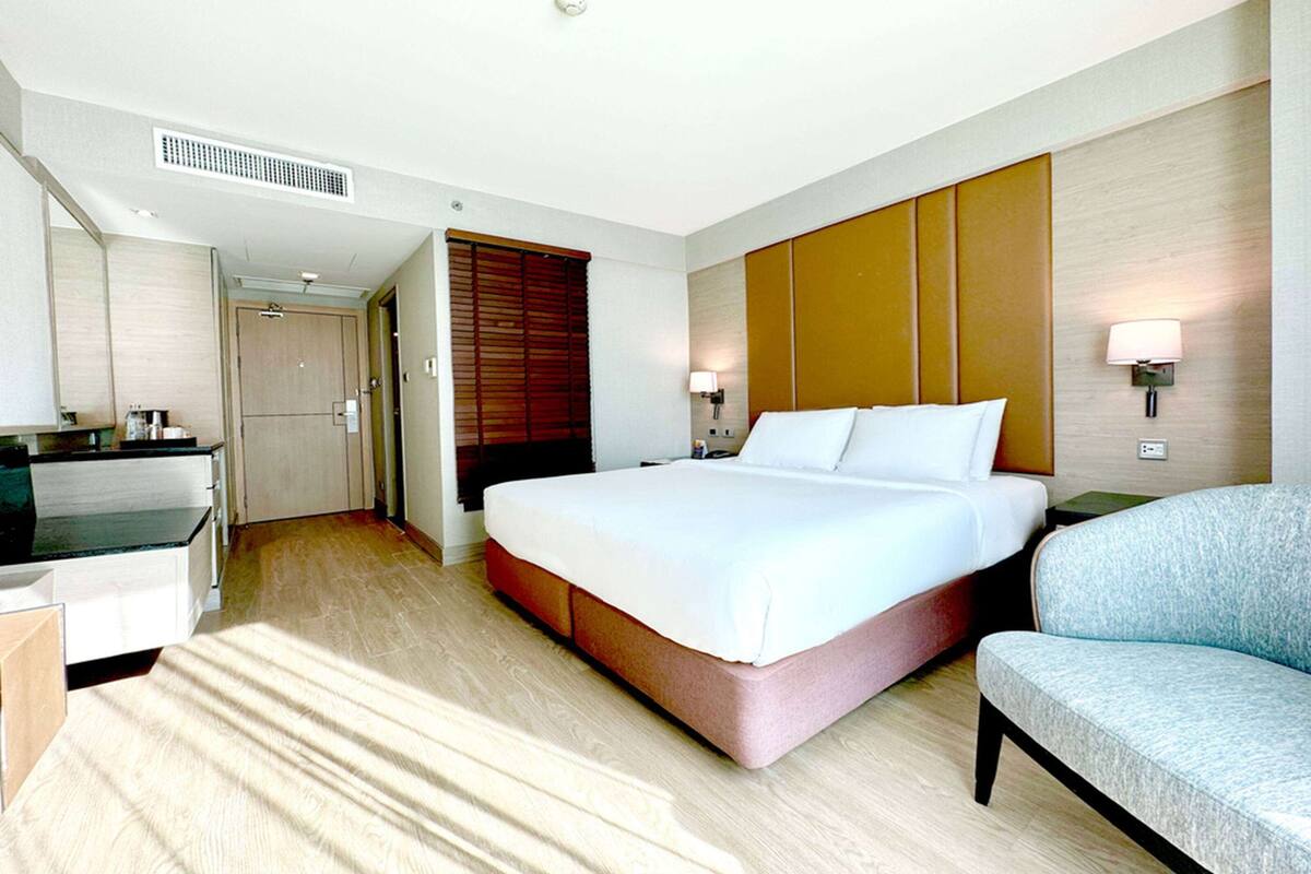 Una habitación de hotel con cama, escritorio, silla y baño.