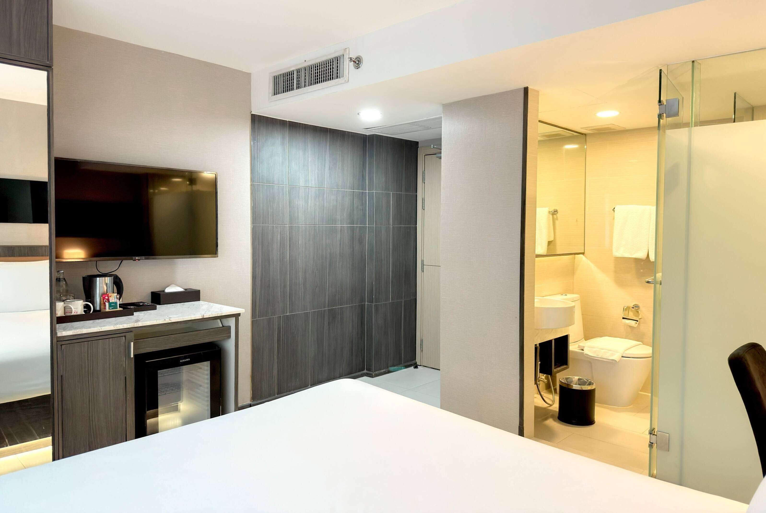 Een moderne badkamer met een douchecabine van glas, een toilet en een wastafel.
