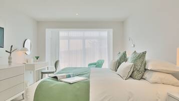 Un dormitorio moderno con una cama grande, un escritorio y una silla.