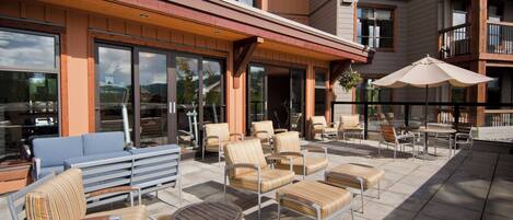 An outdoor patio with multiple seating areas, including sofas and chairs, and a table.