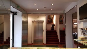 Un interior con una escalera, un ascensor y una exhibición de moneda.