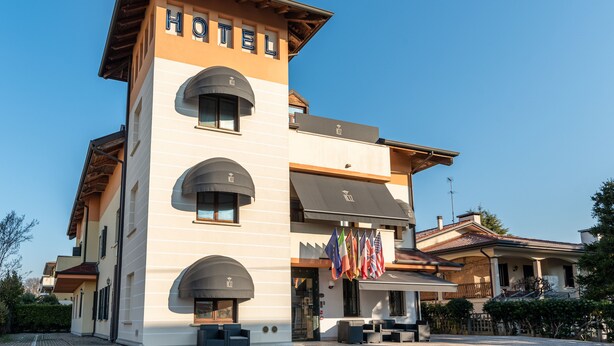 Un hotel con un llamativo letrero que dice 'HOTEL', múltiples balcones y banderas.