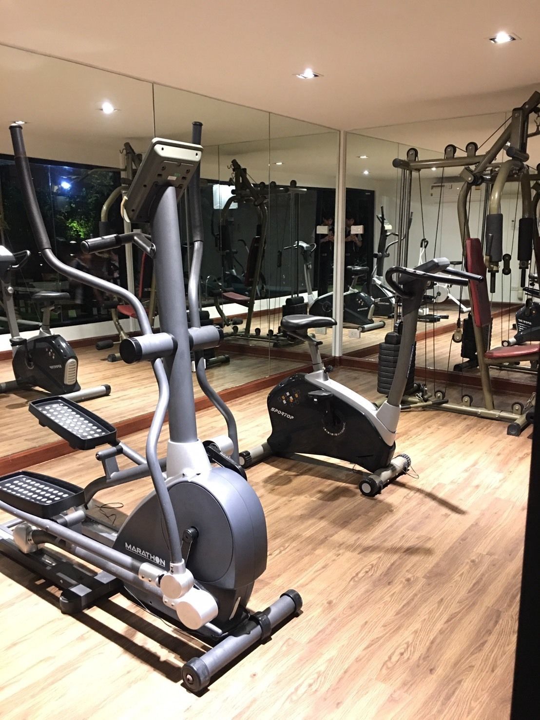A gym with various exercise equipment, including an elliptical and a stationary bike.