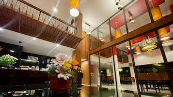 A modern interior with a staircase, seating area, and decorative lighting.