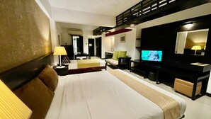 A hotel room with a bed, a desk, a television, and a mirror. - Siam Piman Hotel (Bangkok)