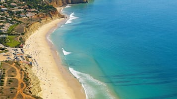En la playa, playa de arena blanca, camastros y sombrillas