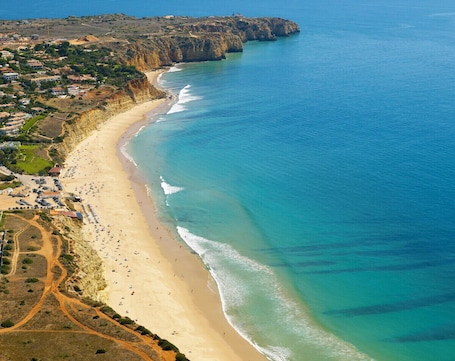En la playa, arena blanca, sillas reclinables de playa, sombrillas