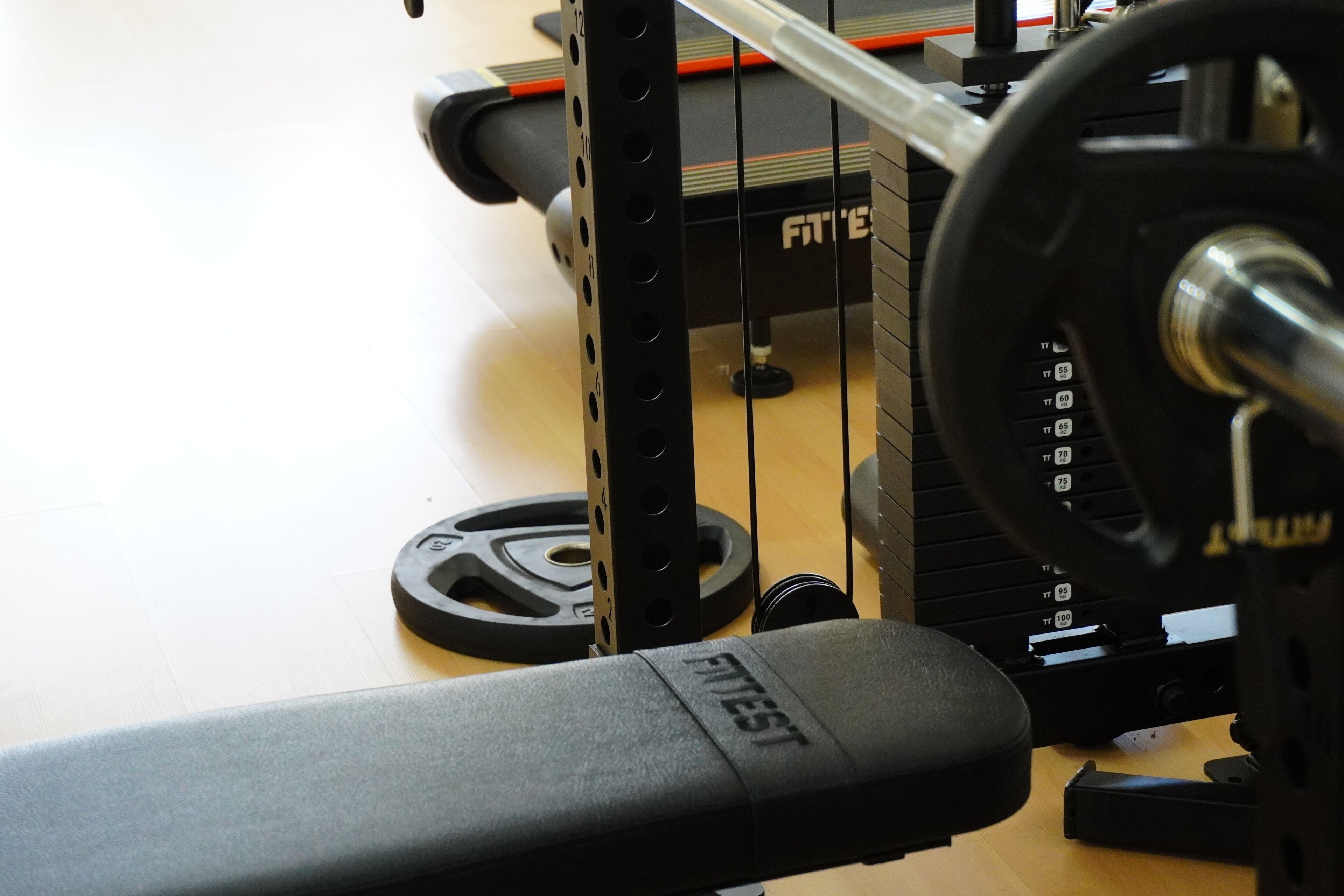A weight bench with a barbell and weight plates.