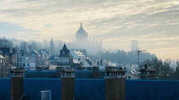 A cityscape with a prominent domed building in the background, surrounded by residential buildings and a clear sky.