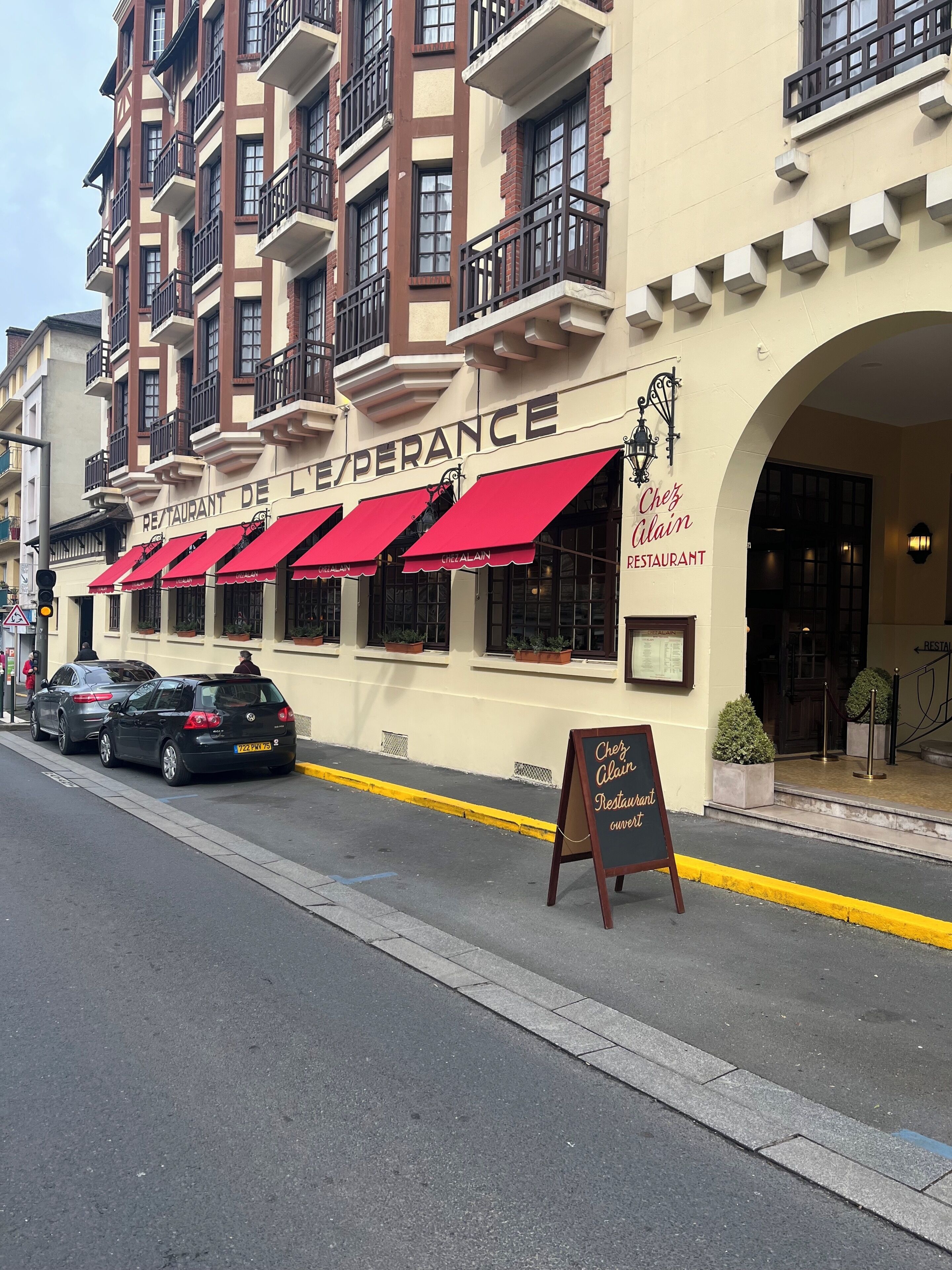 A restaurant with red awnings and a sign reading 'Chef Alain's Restaurant.'